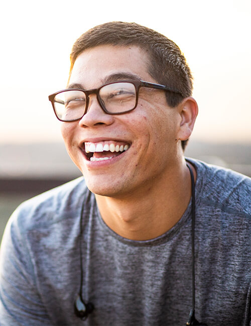 A young man with glasses smiling