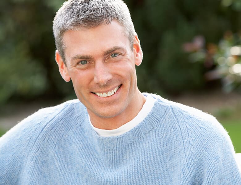 Man with gray hair smiling outdoors